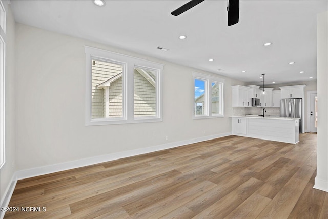 unfurnished living room with baseboards, light wood finished floors, visible vents, and recessed lighting