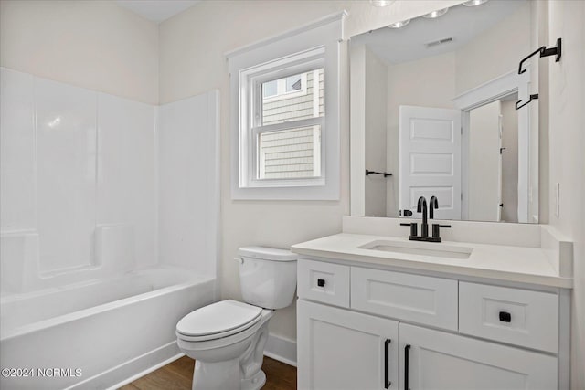 full bath with shower / bath combination, visible vents, toilet, wood finished floors, and vanity