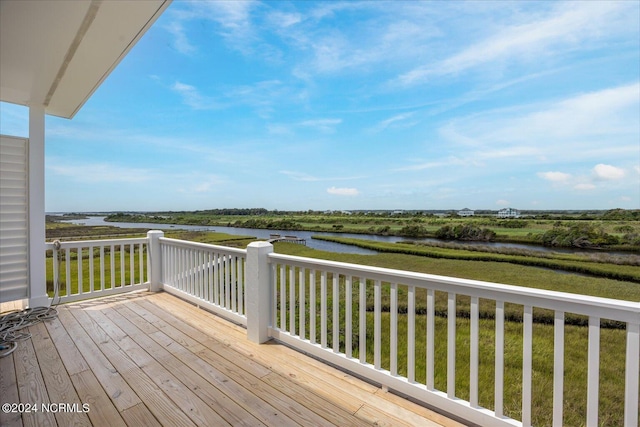 deck featuring a lawn and a water view