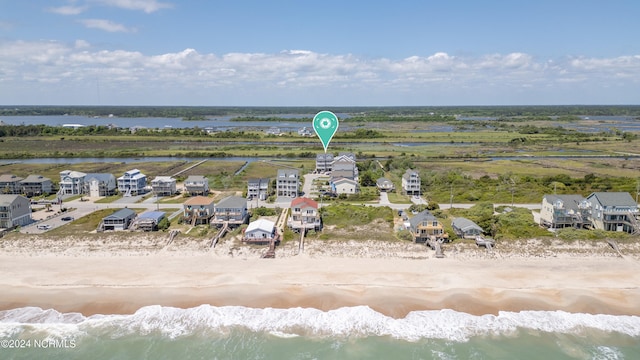 birds eye view of property featuring a water view, a residential view, and a beach view