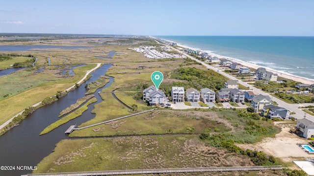 drone / aerial view with a water view and a beach view