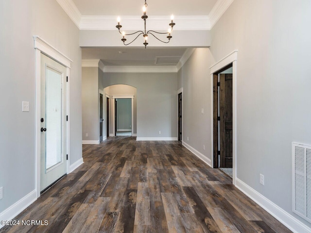 corridor with dark hardwood / wood-style flooring, ornamental molding, and an inviting chandelier