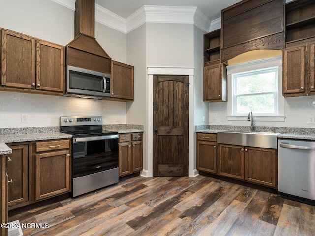 kitchen featuring sink, crown molding, dark hardwood / wood-style floors, light stone countertops, and stainless steel appliances