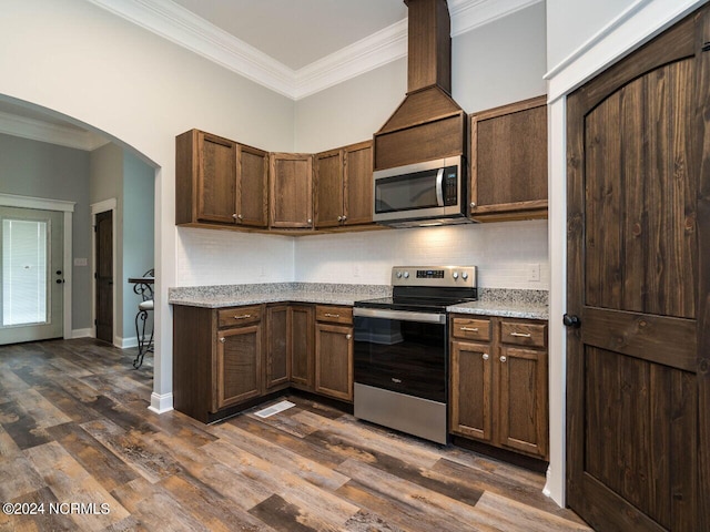 kitchen with backsplash, crown molding, stainless steel appliances, and dark hardwood / wood-style floors