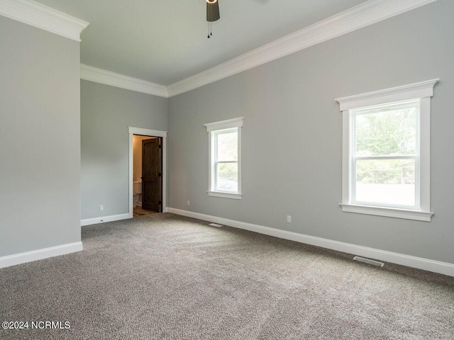 carpeted spare room featuring crown molding and ceiling fan