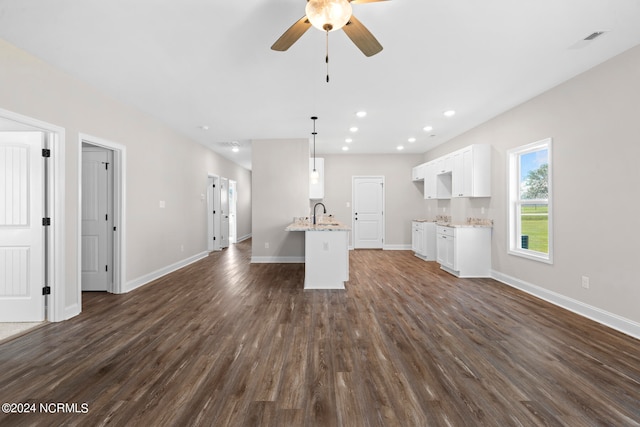 unfurnished living room featuring ceiling fan and dark hardwood / wood-style floors