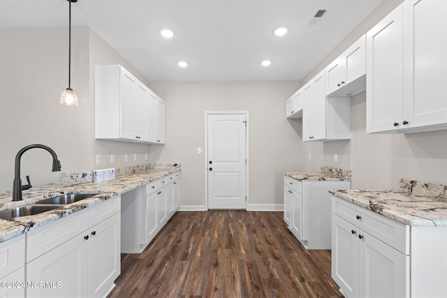 kitchen featuring pendant lighting, white cabinetry, dark wood-type flooring, and sink