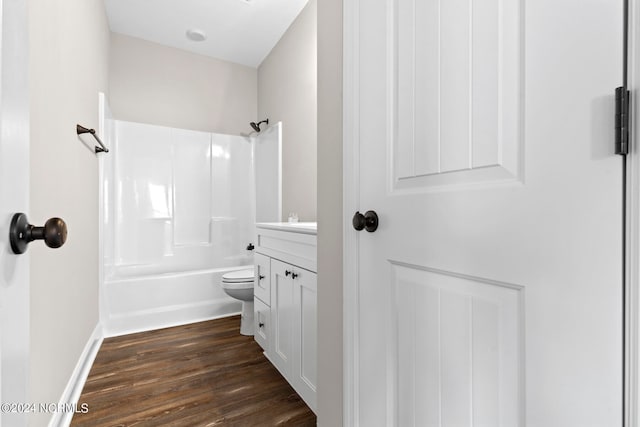 full bathroom with vanity, toilet, washtub / shower combination, and hardwood / wood-style flooring