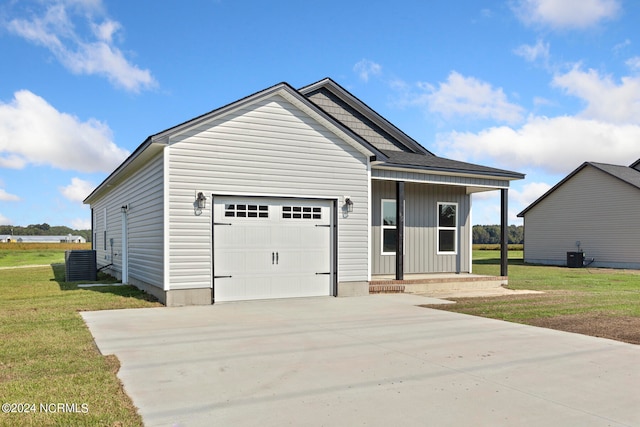 view of front facade with a garage, central AC, and a front yard