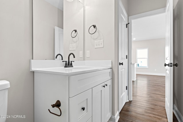 bathroom with vanity, toilet, and hardwood / wood-style flooring