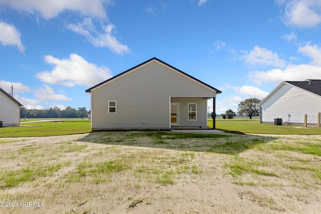 rear view of property with a lawn and cooling unit