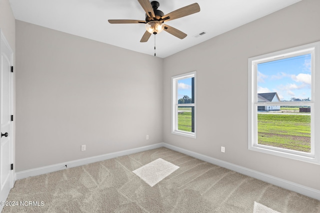 empty room with light carpet, ceiling fan, and plenty of natural light