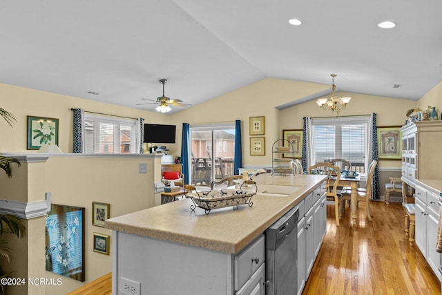 kitchen with light wood-type flooring, stainless steel dishwasher, decorative light fixtures, a center island, and lofted ceiling