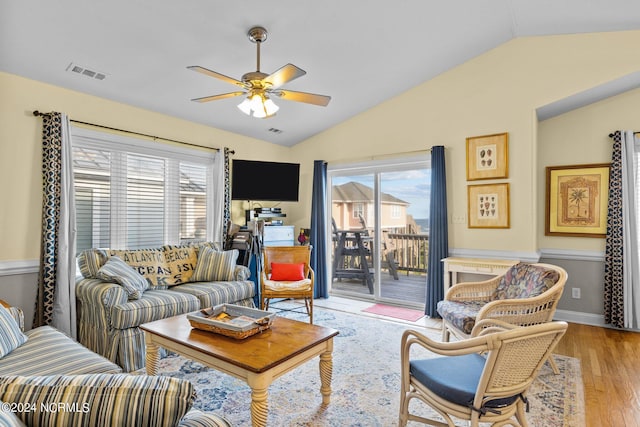 living room featuring ceiling fan, light hardwood / wood-style flooring, and vaulted ceiling