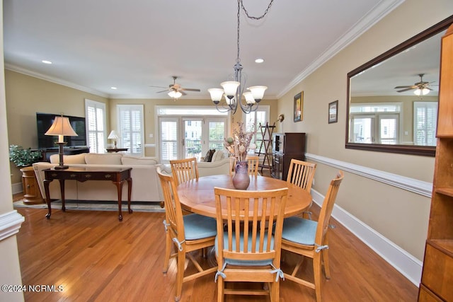 dining room with ornamental molding, a notable chandelier, and light wood-type flooring