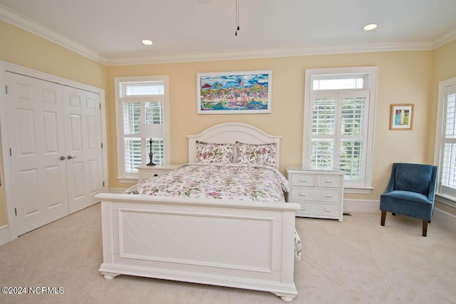 carpeted bedroom featuring multiple windows, crown molding, and a closet