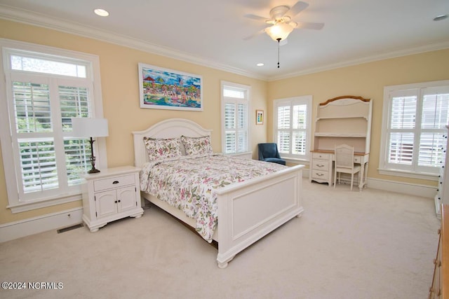 carpeted bedroom with ornamental molding and ceiling fan