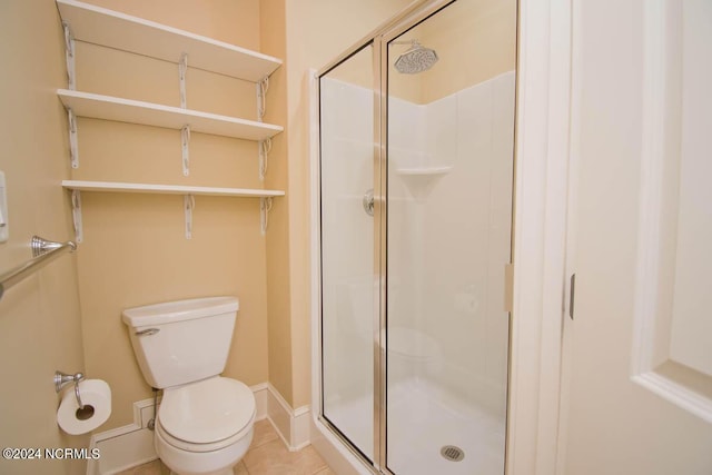 bathroom featuring tile patterned floors, toilet, and an enclosed shower