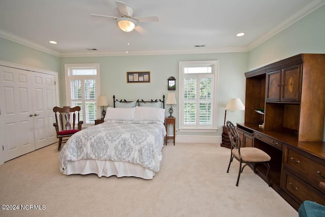 carpeted bedroom with ceiling fan, ornamental molding, and a closet