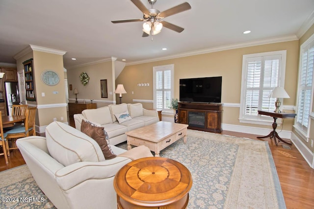 living room featuring crown molding, light hardwood / wood-style flooring, and ceiling fan