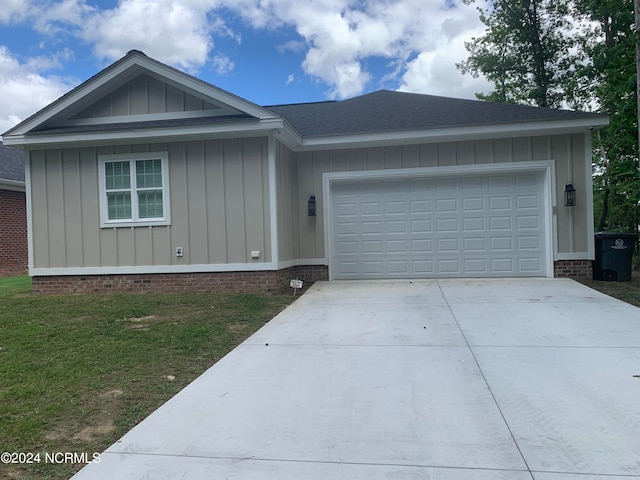 ranch-style home with a garage and a front lawn