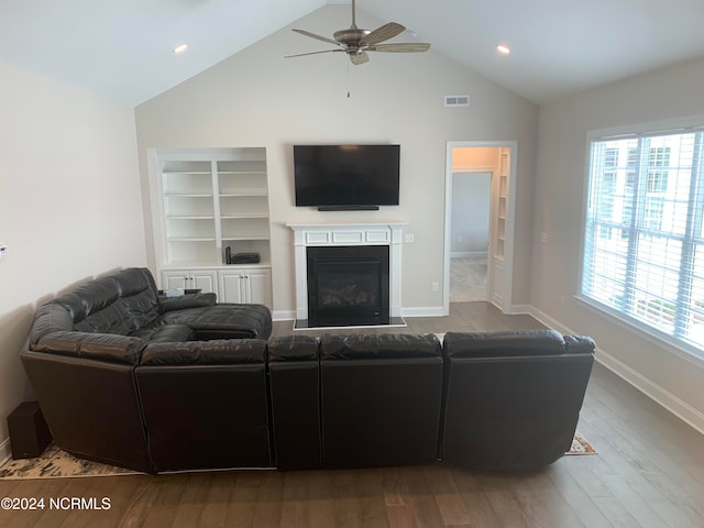 living room with hardwood / wood-style flooring, ceiling fan, and vaulted ceiling