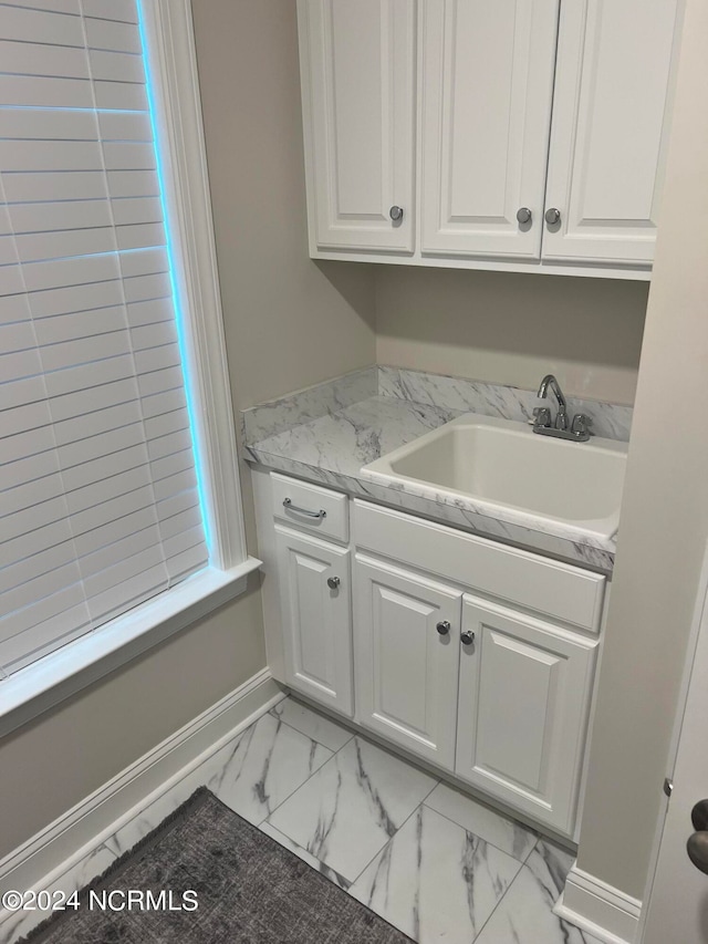 clothes washing area featuring sink and light tile floors