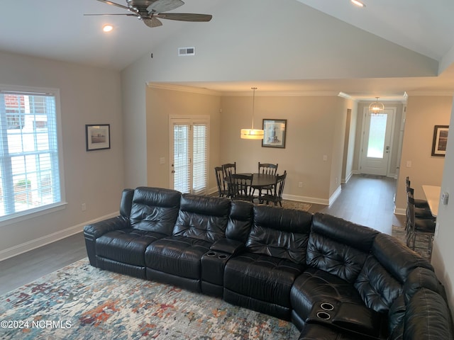 living room with a wealth of natural light, wood-type flooring, ceiling fan, and vaulted ceiling