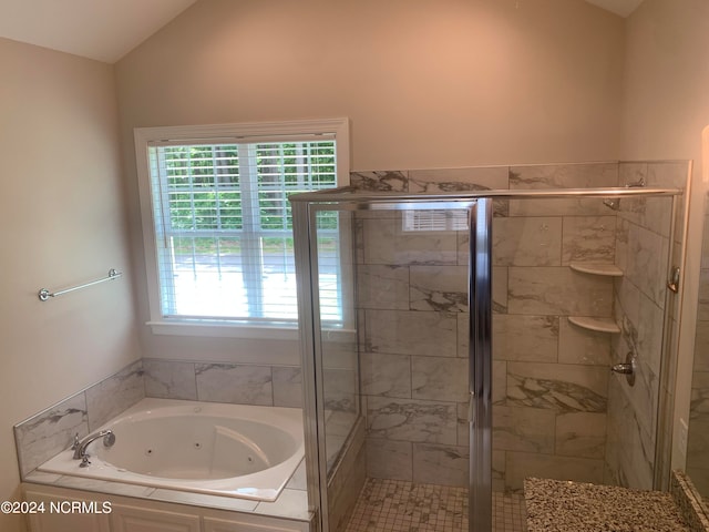 bathroom with plenty of natural light, lofted ceiling, and independent shower and bath