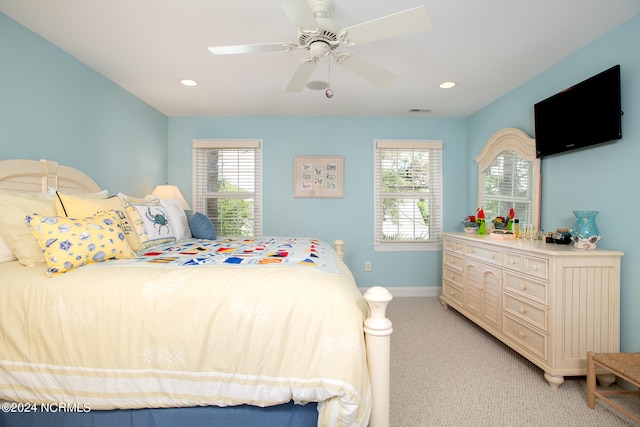 carpeted bedroom featuring ceiling fan and multiple windows