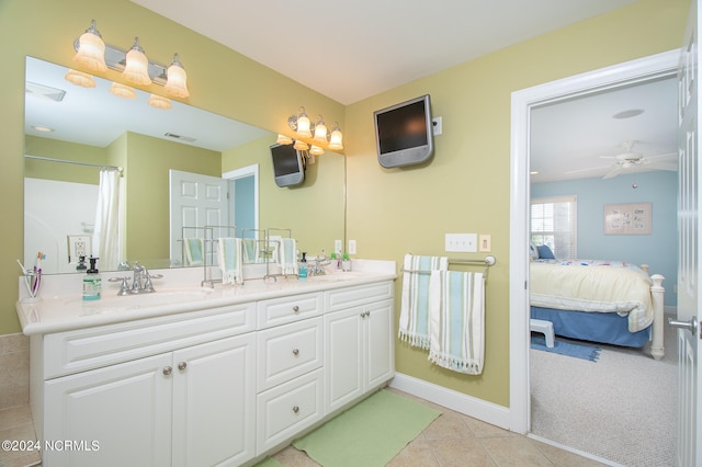 bathroom featuring tile floors, ceiling fan, oversized vanity, and double sink