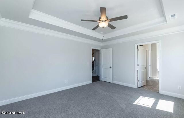 unfurnished bedroom featuring crown molding, a tray ceiling, and carpet flooring