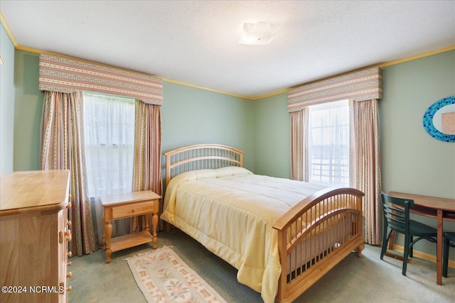 carpeted bedroom with ornamental molding and a textured ceiling