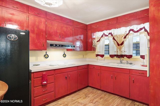 kitchen with sink, black fridge, crown molding, white electric stovetop, and light wood-type flooring