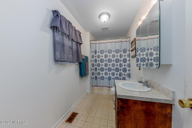 bathroom with toilet, tile floors, and large vanity