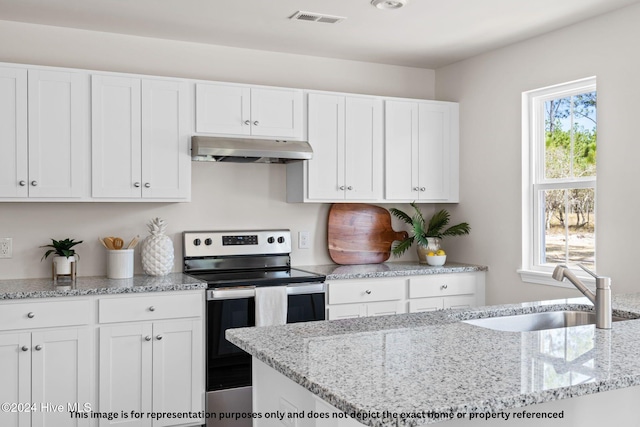 kitchen featuring a wealth of natural light, sink, white cabinets, and electric stove