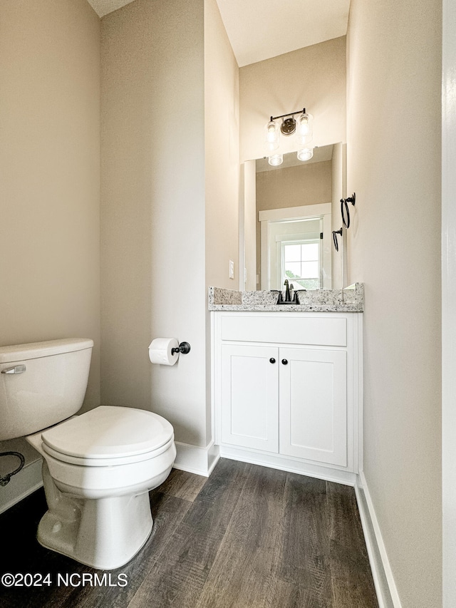 bathroom featuring toilet, hardwood / wood-style flooring, and vanity