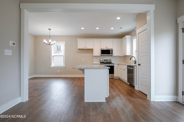 kitchen with white cabinetry, stainless steel appliances, dark wood-type flooring, pendant lighting, and a center island