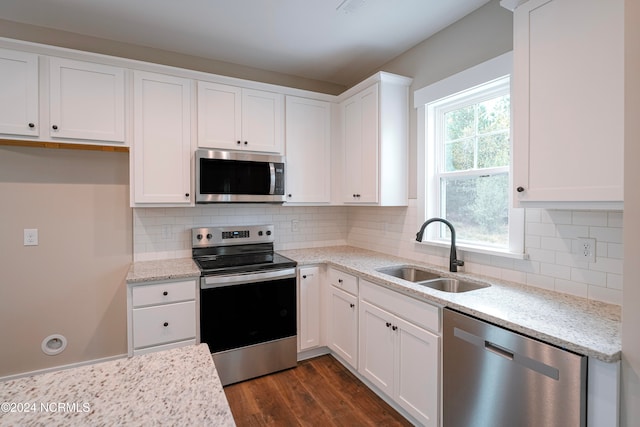 kitchen with white cabinets, backsplash, dark hardwood / wood-style flooring, sink, and stainless steel appliances