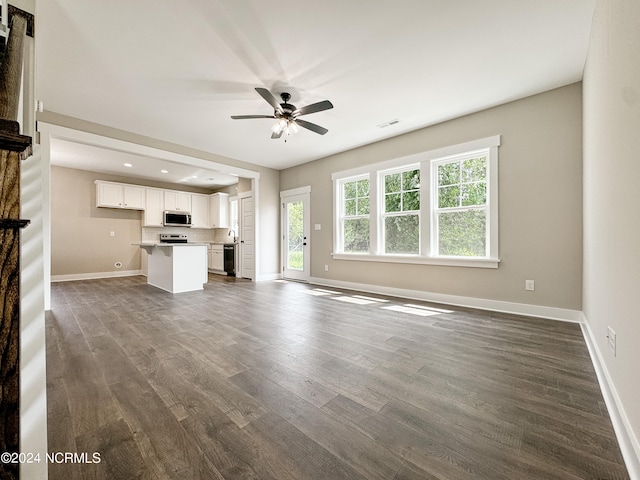 unfurnished living room featuring ceiling fan and dark hardwood / wood-style flooring