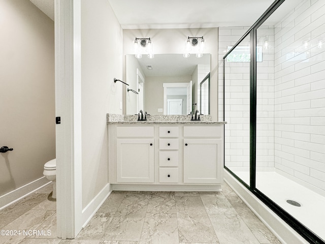 bathroom featuring vanity, a shower with shower door, and toilet