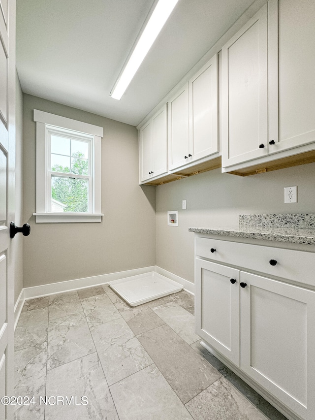 laundry area with hookup for a washing machine and cabinets