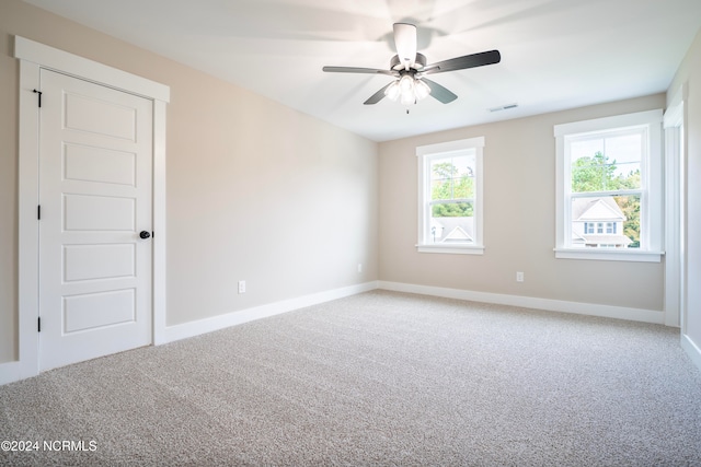 carpeted spare room with ceiling fan