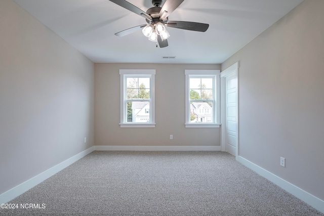 carpeted spare room featuring ceiling fan