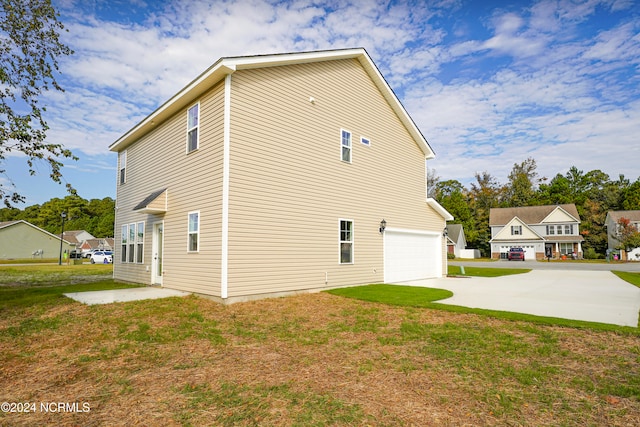 view of side of home with a garage and a lawn