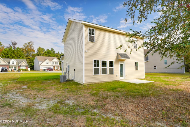 rear view of property with a lawn, a patio area, and central AC unit