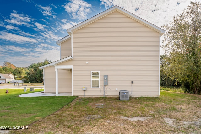 view of property exterior with a patio area, central AC unit, and a lawn