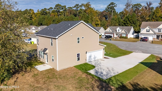 view of side of home featuring a yard and a garage