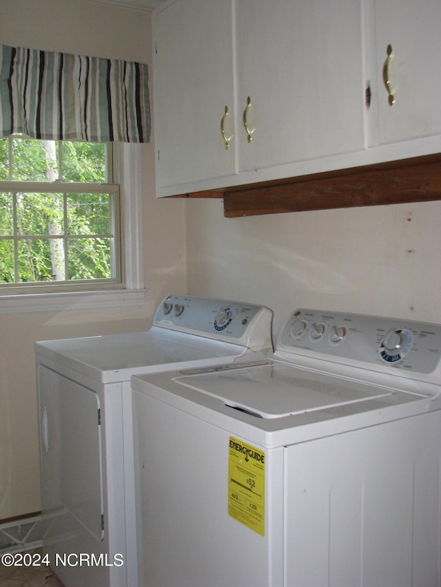 laundry room with washing machine and dryer and cabinets