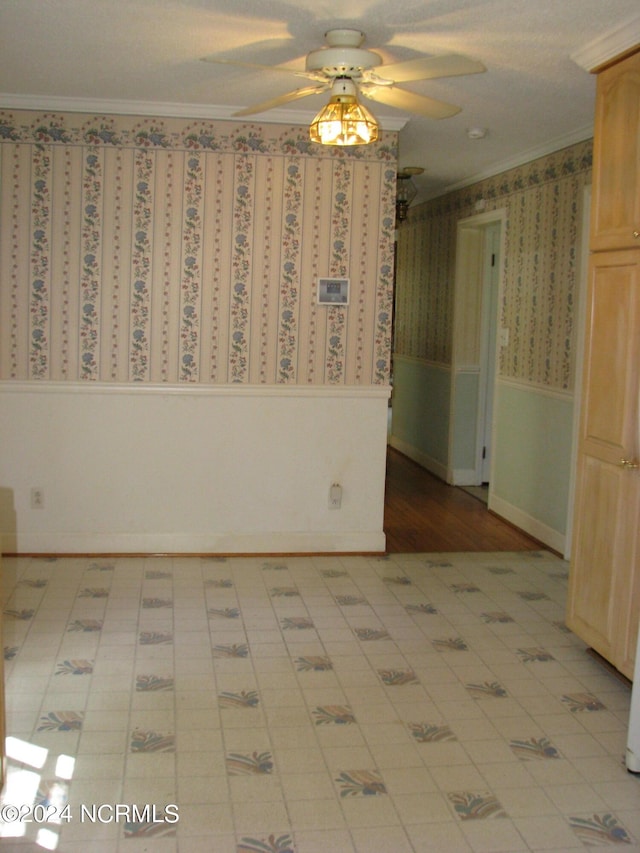 empty room featuring ceiling fan and ornamental molding